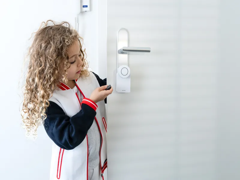 A girl opening the door with the Nuki Fob remote